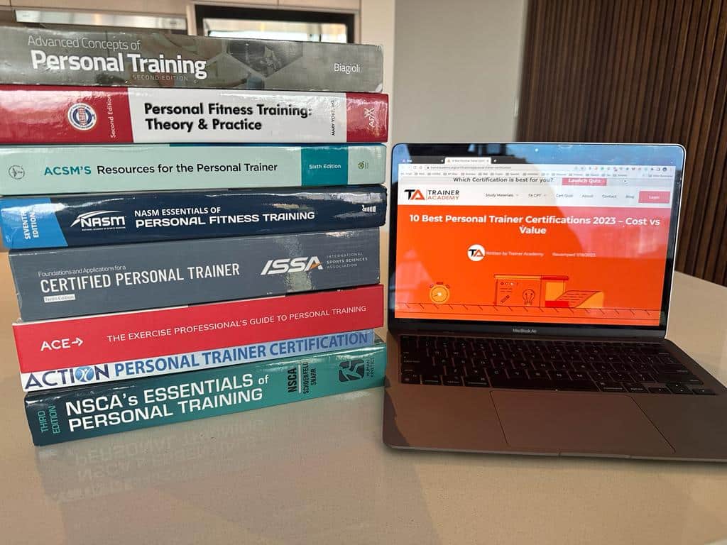 Best personal training certification textbooks stacked on desk. List of NCCA accreditation for the top personal training certifications