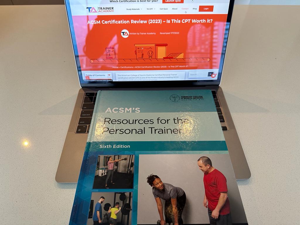 ACSM CPT textbook showing the front cover and on top of a laptop