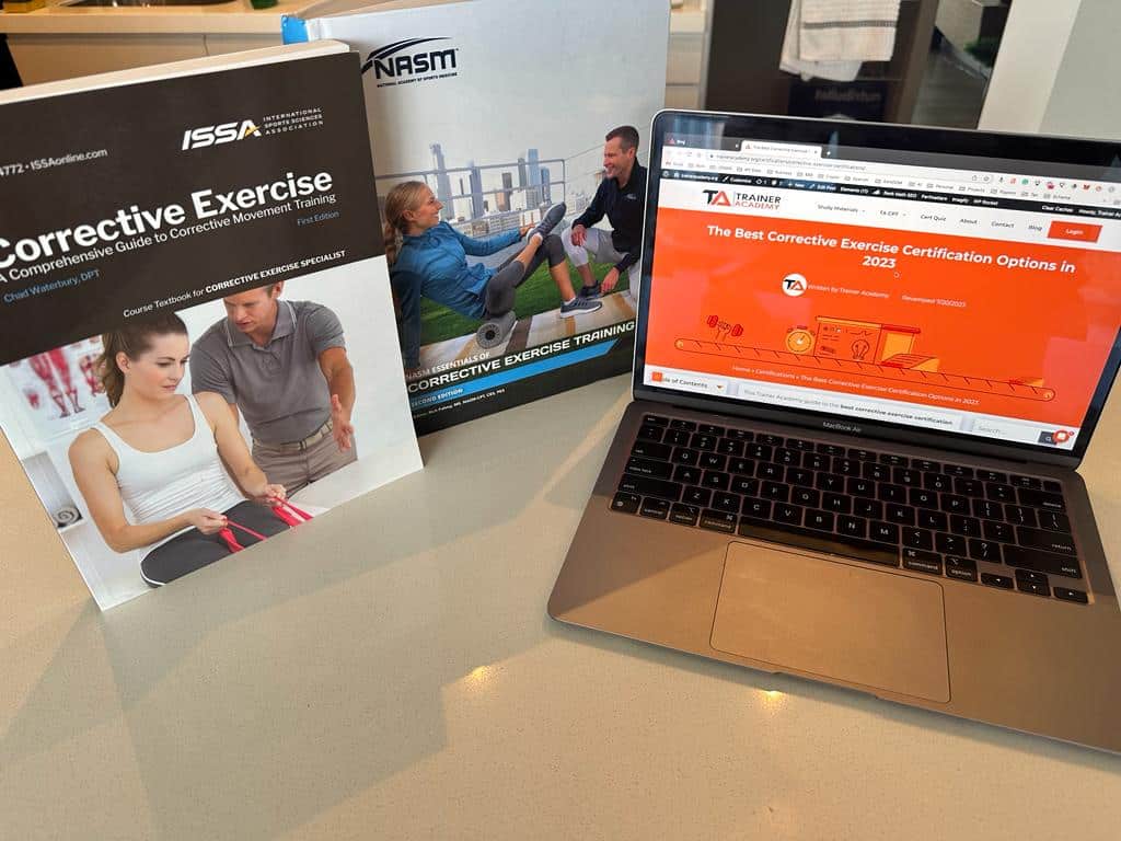 ISSA and NASM textbook covers showing with laptop open to the comparison article