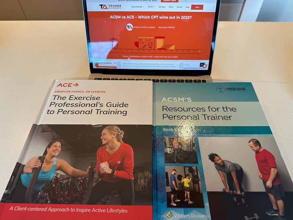 The ACE cpt textbook and ACSM cpt textbook on a laptop open to the comparison article page