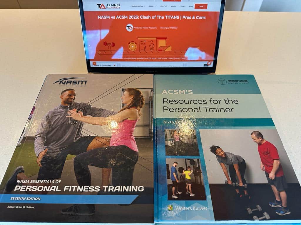 The NASM and ACSM cpt cert textbooks on top of a laptop showing the comparison article